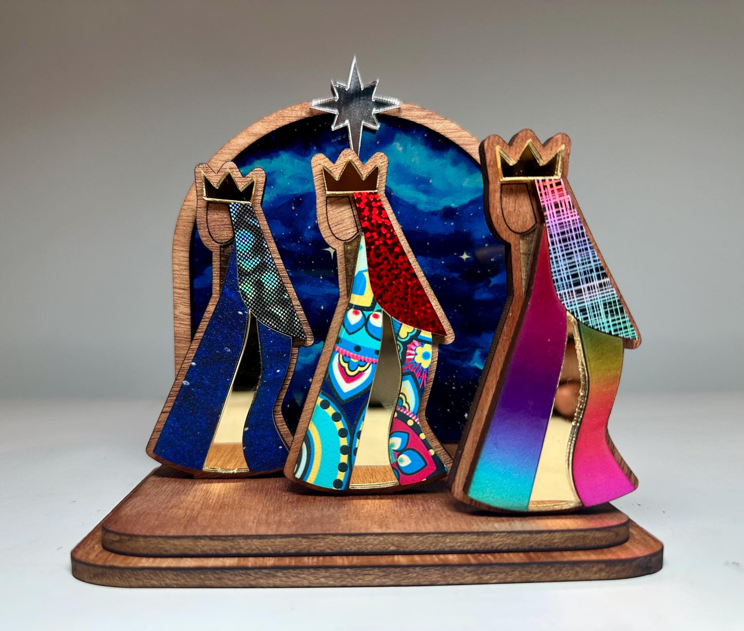 Mahogany kings with colorful robes in front of a night sky, tres Reyes shelf sitter